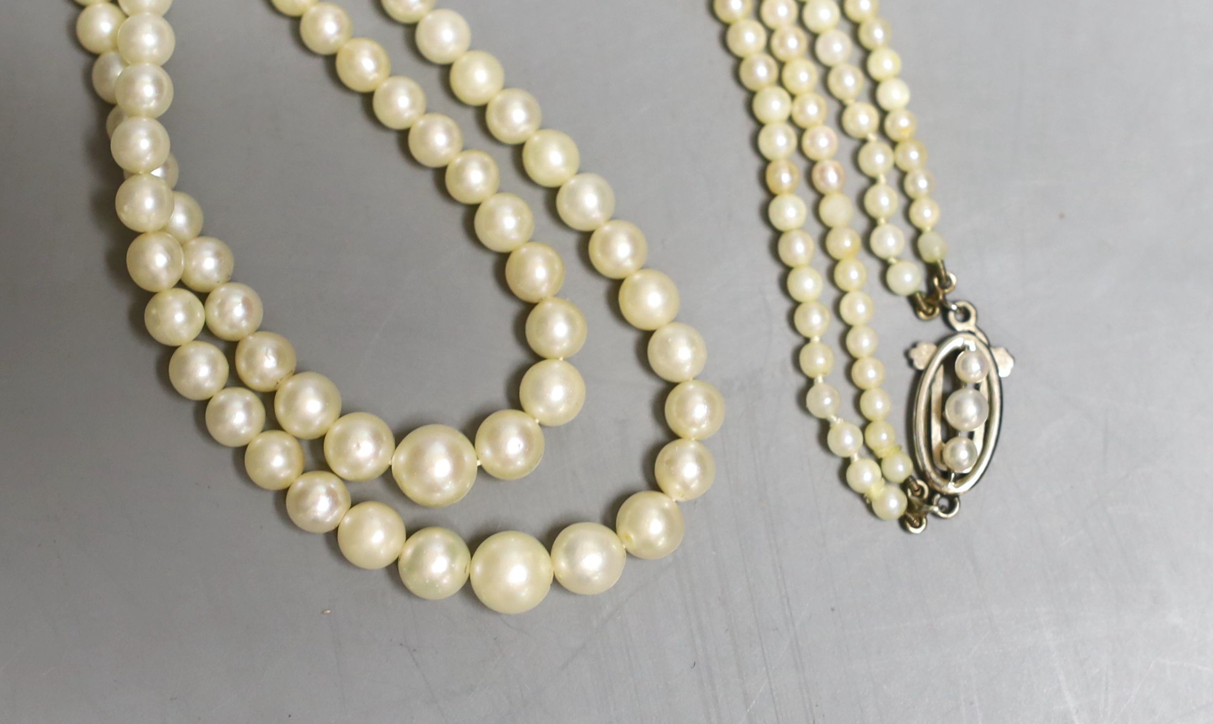 A double strand graduated cultured pearl necklace, with white metal and cultured pearl set clasp, 45cm.